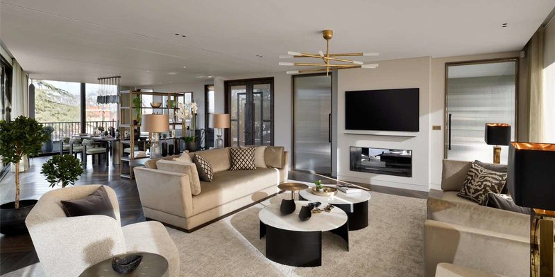 The living floor of a finished North London house: sofas around marble tables, a brass chandelier and a wall of glazing onto trees.